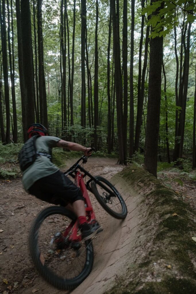 Dynamic mountain biking experience captured in dense forest trail.